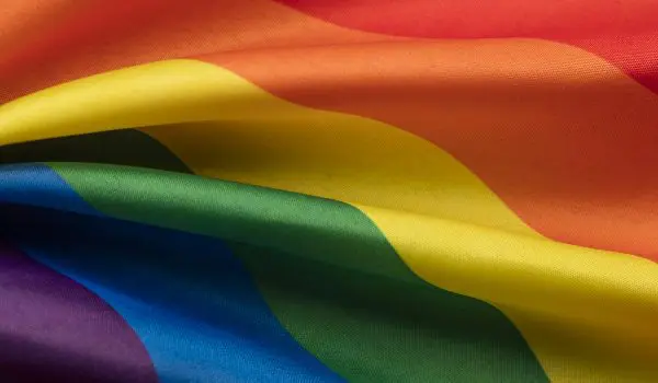 A vibrant rainbow flag with colors red, orange, yellow, green, blue, and purple.