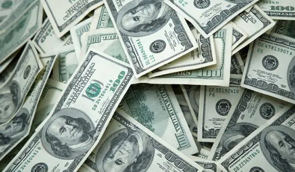 A pile of scattered US hundred-dollar bills.