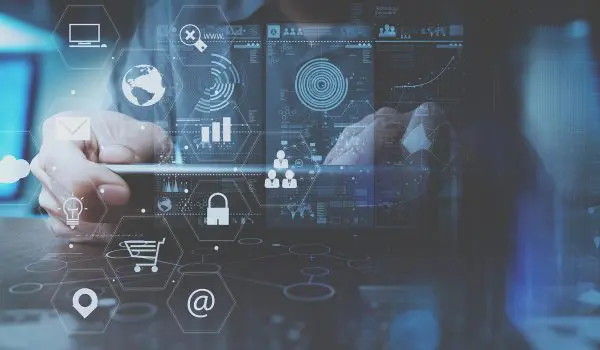 A person interacts with a futuristic holographic interface displaying various data visualizations and digital icons representing connectivity, security, and technology.