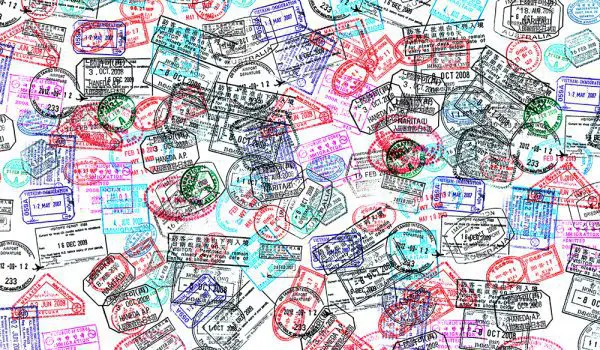 A collection of various colorful passport stamps overlapping each other.