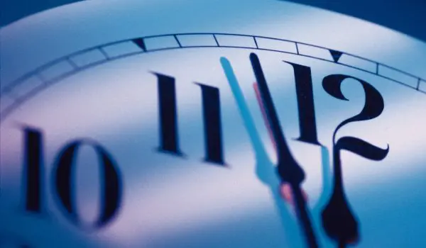 A close-up view of a clock showing the time approaching midnight.