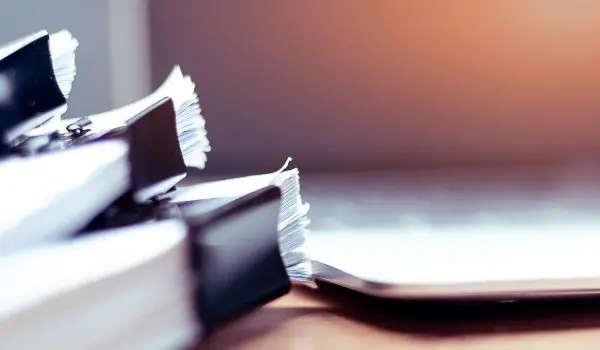 Stack of papers in front of computer