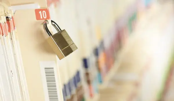 A padlock secures locker number 10 in a corridor lined with lockers.