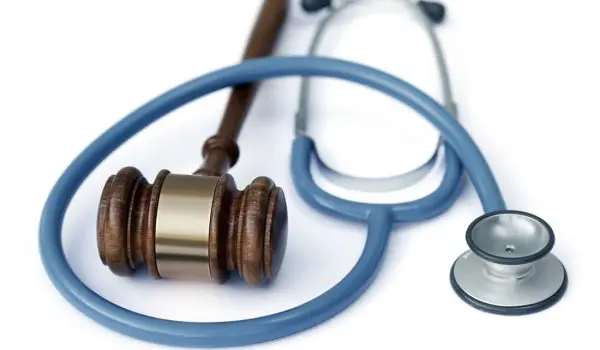 A wooden gavel rests beside a stethoscope, symbolizing the intersection of law and healthcare.