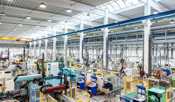 An industrial facility with machinery and equipment, potentially for manufacturing or assembly, is depicted with bright lighting and a clean, organized layout.