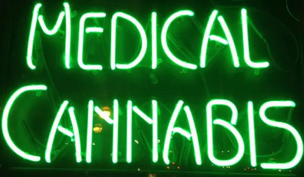 A glowing neon sign reads "MEDICAL CANNABIS" in bright green letters.