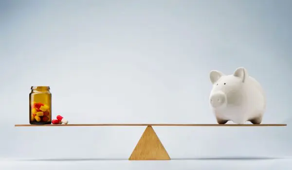 A piggy bank is balanced on a seesaw against a jar filled with coins and accompanied by small objects.