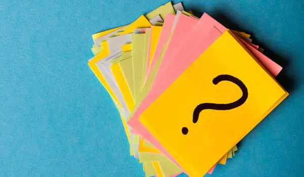 A stack of colorful sticky notes with a question mark on the top note is arranged against a blue background.