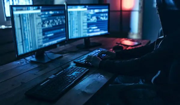 hacker in dark room behind data breach
