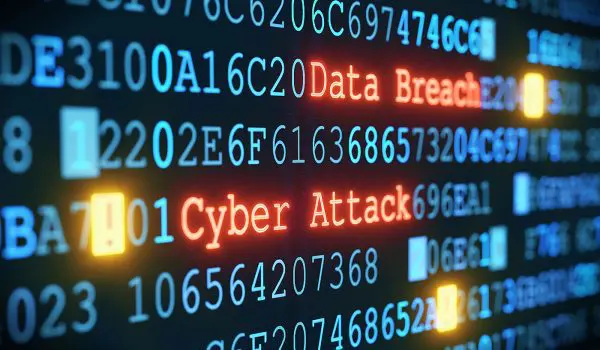A digital screen displays a series of alphanumeric codes along with the words "Data Breach" and "Cyber Attack" in a high-contrast, blue and orange color scheme, suggesting a security breach or hacking incident.