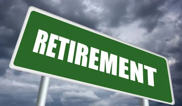 A green road sign with the word "RETIREMENT" on it against a cloudy sky backdrop.