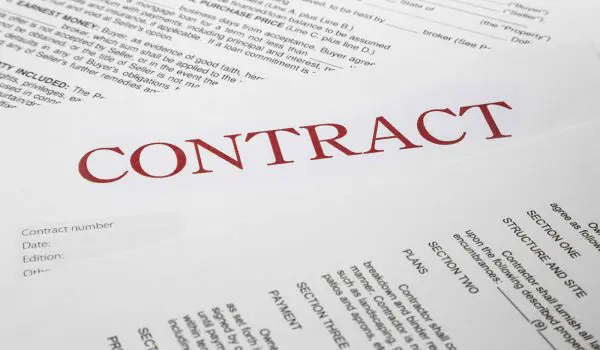 A contract document with bold red text and various clauses and sections visible.