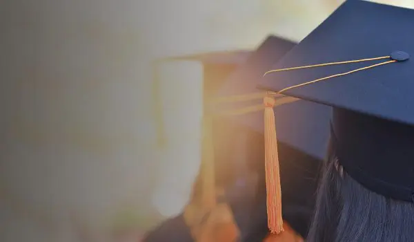 Two graduation caps with tassels are visible from behind.