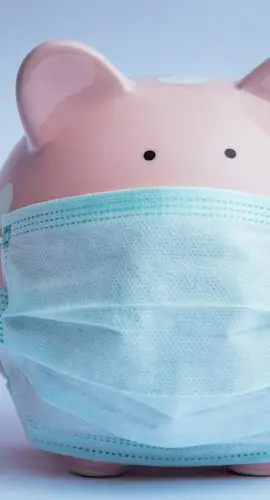 A piggy bank is wearing a medical face mask.