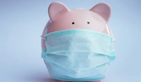 A piggy bank is wearing a medical face mask.