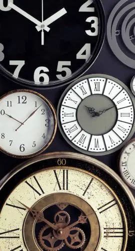 A collection of variously styled analogue clocks with different designs and numbers fills the frame.