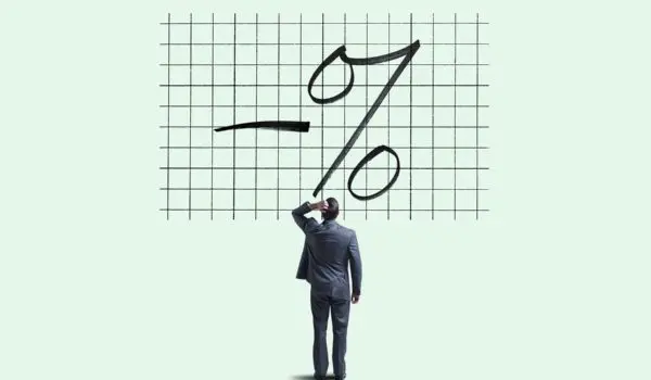 A man stands looking at a large grid chart with a negative percentage symbol drawn on it.
