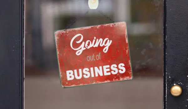 A red sign with white text reading "Going out of BUSINESS" is displayed on a glass door.
