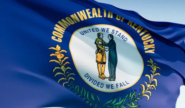 A flag with "Commonwealth of Kentucky" and "United We Stand, Divided We Fall" surrounding a seal depicting two men shaking hands.