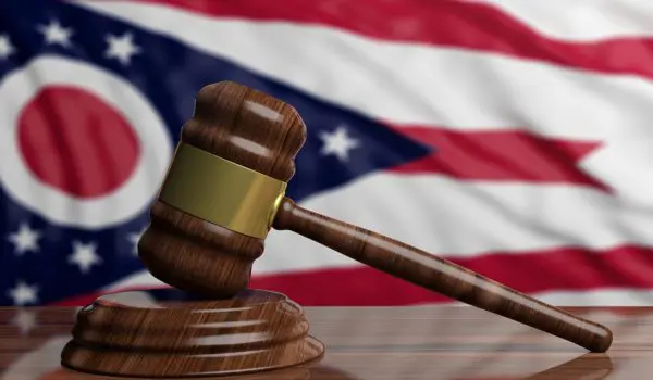 A judge's gavel is positioned in front of an Ohio state flag.