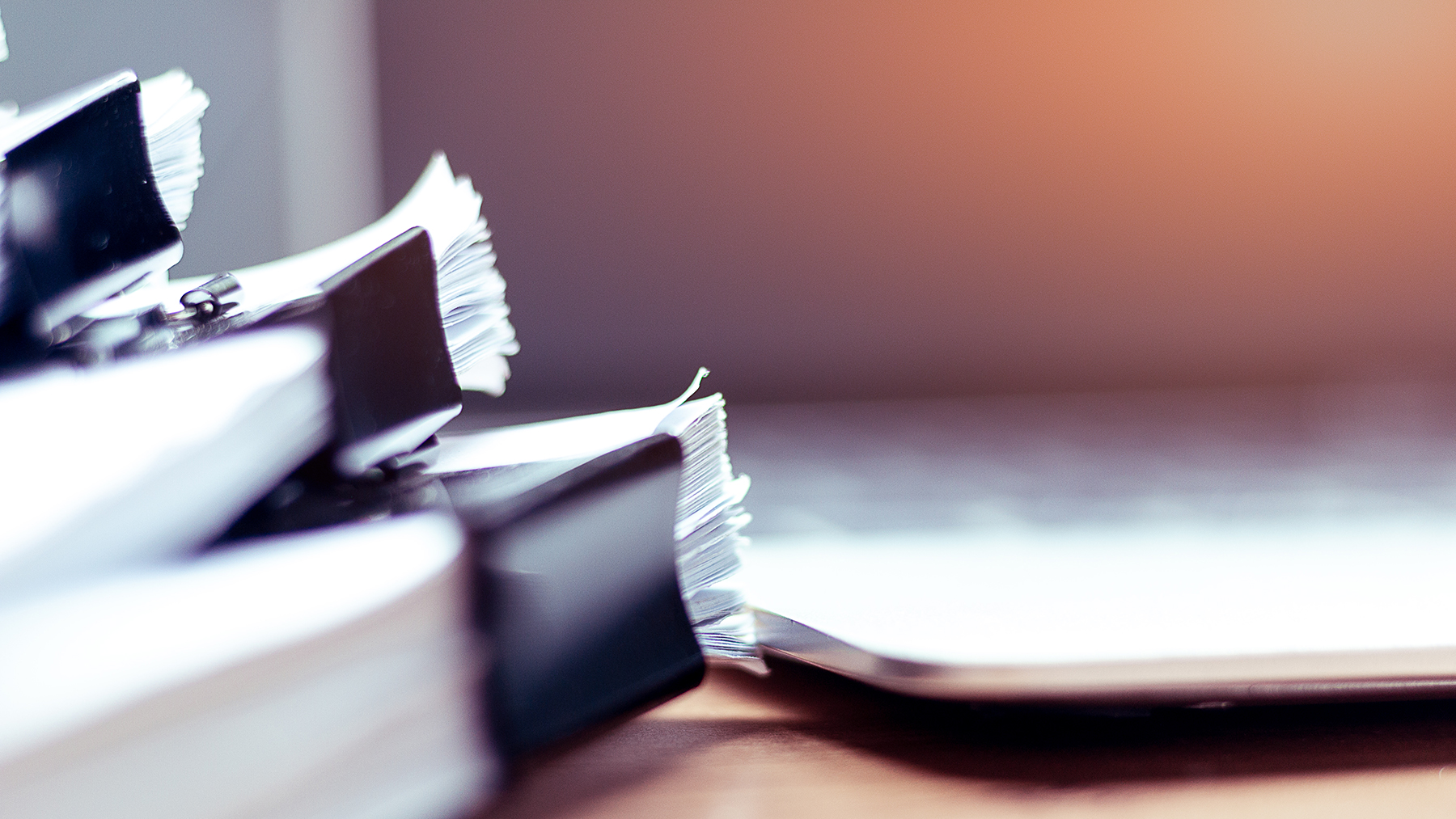 Stack of papers in front of computer