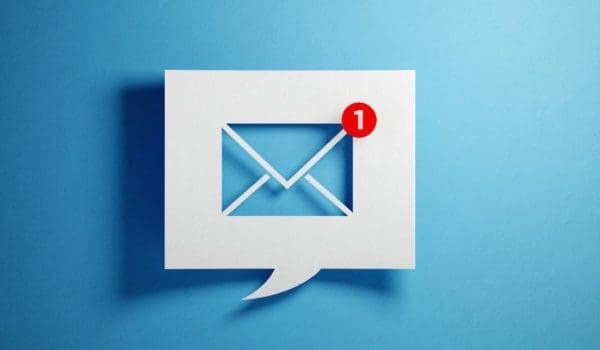 White chat bubble with email symbol on blue background. Horizontal composition with copy space.