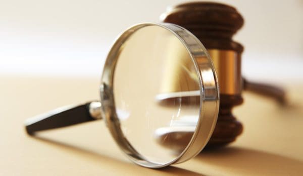 A gavel seen through a magnifying glass.  Photographed with a very shallow depth of field.