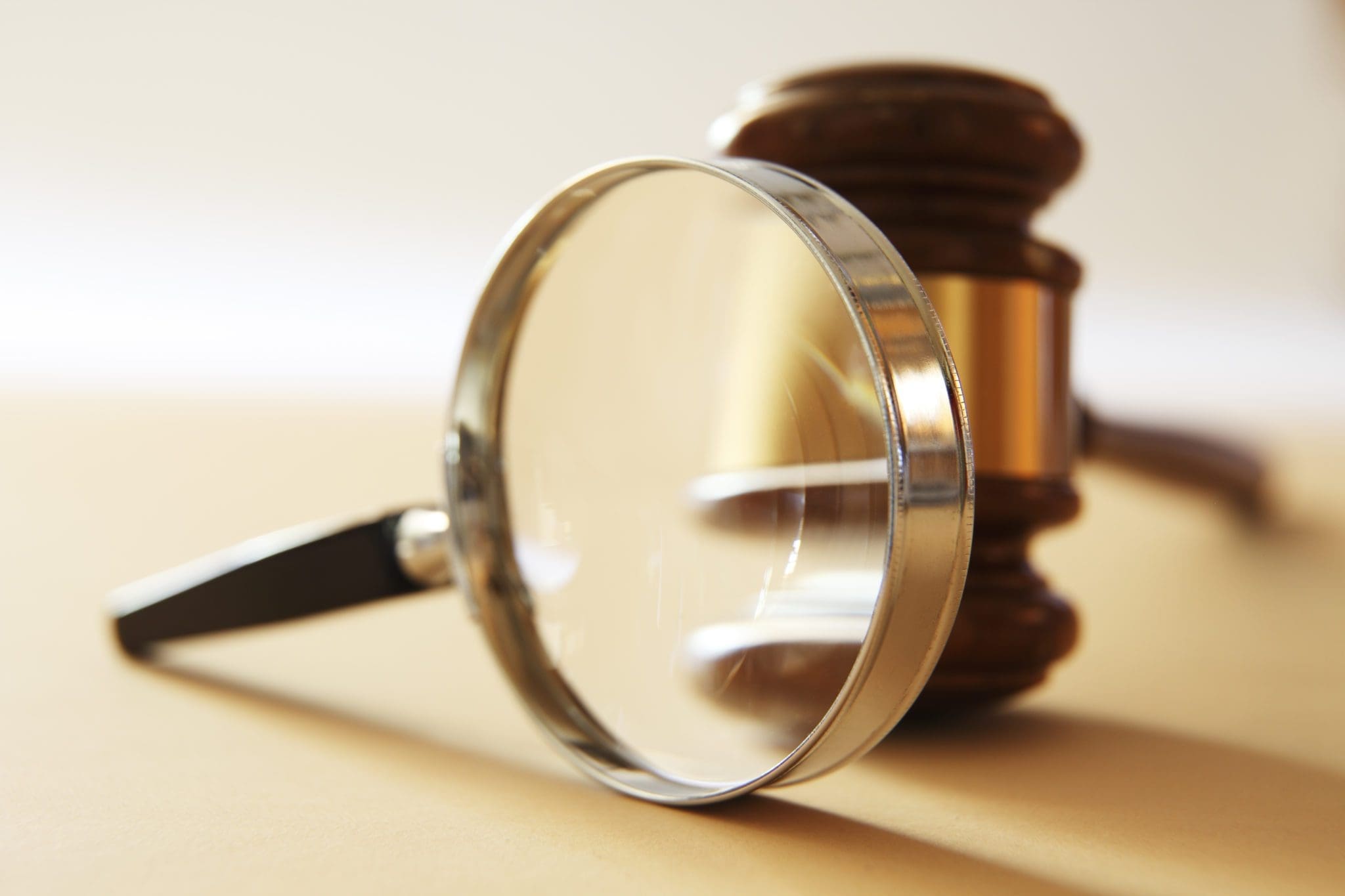 A gavel seen through a magnifying glass.  Photographed with a very shallow depth of field.