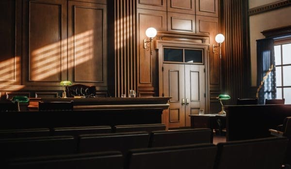 Empty American Style Courtroom. Supreme Court of Law and Justice Trial Stand. Courthouse Before Civil Case Hearing Starts. Grand Wooden Interior with Judge's Bench, Defendant's and Plaintiff's Tables.