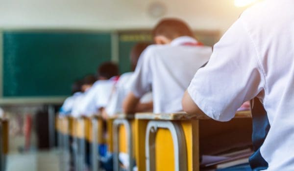 Rear view of middle school students studying in classroom
