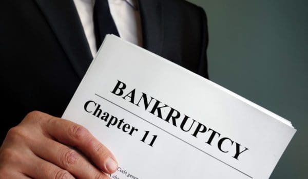 Man holds Bankruptcy Chapter 11 agreement documents.