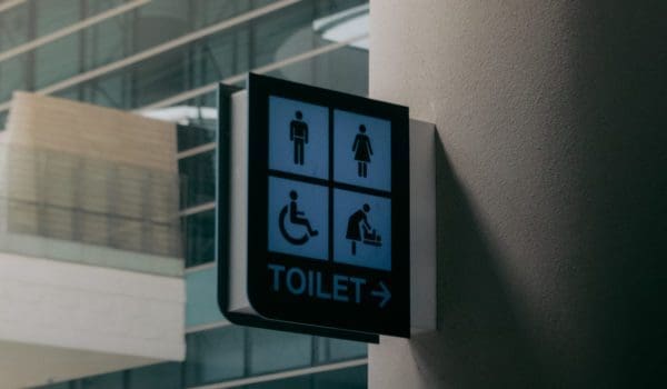 Signboard of public toilet placed on wall