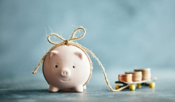 Little Pink Piggy Bank Pulling His Savings on a Skateboard