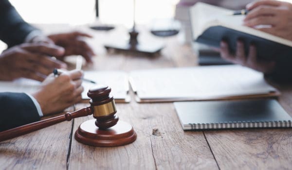 Close-up of a judge with a hammer against the background of professional lawyer talking about a lawsuit. professional lawyers discussing legal case.