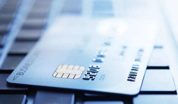 Blue tinted image of credit card on laptop with shallow depth of field.