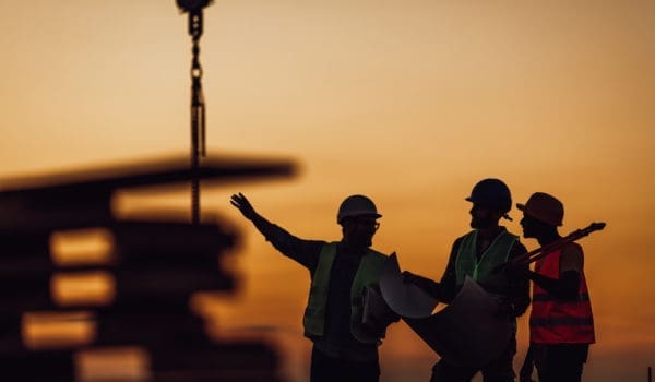 Silhouette of Survey Engineer and construction team working at site over blurred industry background with Light fair Film Grain effect