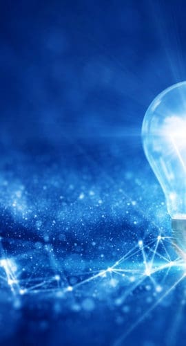 business idea creative concept technology. A light bulb illuminated above a polygon on a dark blue background.