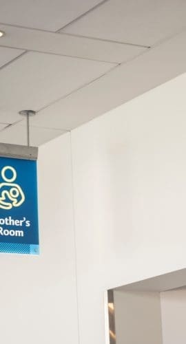 A low angle shot of a blue mother's room sign inside an airport