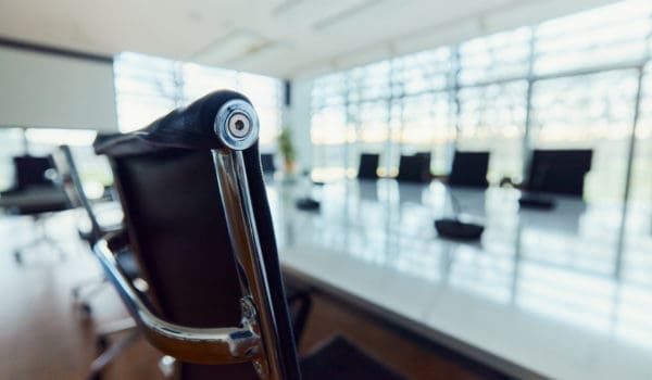 Close up of a black office chair with metal details at conference table in meeting room.