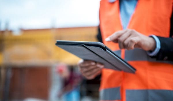 Two architects are using digital tablet on construction site.