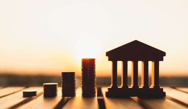 Bank symbol with with coins stack. Concepts of the banking system, rising interest rates, inflation, deflation, and savings.