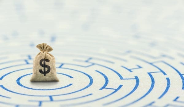 Reducing, removing or overcome financial barrier, financial concept : US dollar bag on a maze puzzle. The image depicting a situation how to overcome financial difficulties and avoid a financial distress.