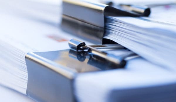Piles of documents with black clip