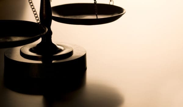 Scales of justice with back-light on wood table. Ideal for home page of law firm website. Can flop and add text as well.