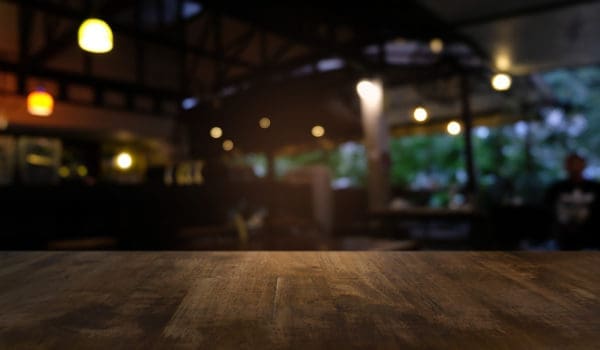 Empty dark wooden table in front of abstract blurred bokeh background of restaurant . can be used for display or montage your products.Mock up for space