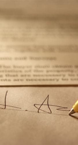 Sepia toned Image of signing a contract with shallow depth of field.