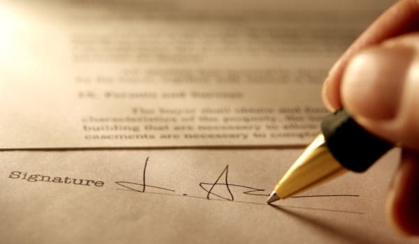 Sepia toned Image of signing a contract with shallow depth of field.
