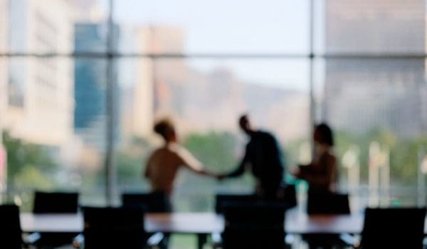 Blurred image of people in a business setting. shaking hands. Family Office Services