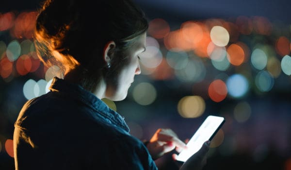 Outdoor, night and woman with smartphone, screen and typing with digital app and texting a contact. City lights, evening or email with person, message or cellphone with social media, tech or internet