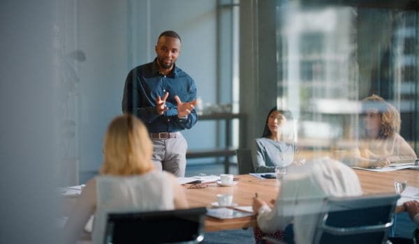 Businessman, meeting and discussion with office, boardroom and collaboration or workshop. Leader, training and presentation for mentor, coaching and strategy for teamwork and planning with startup